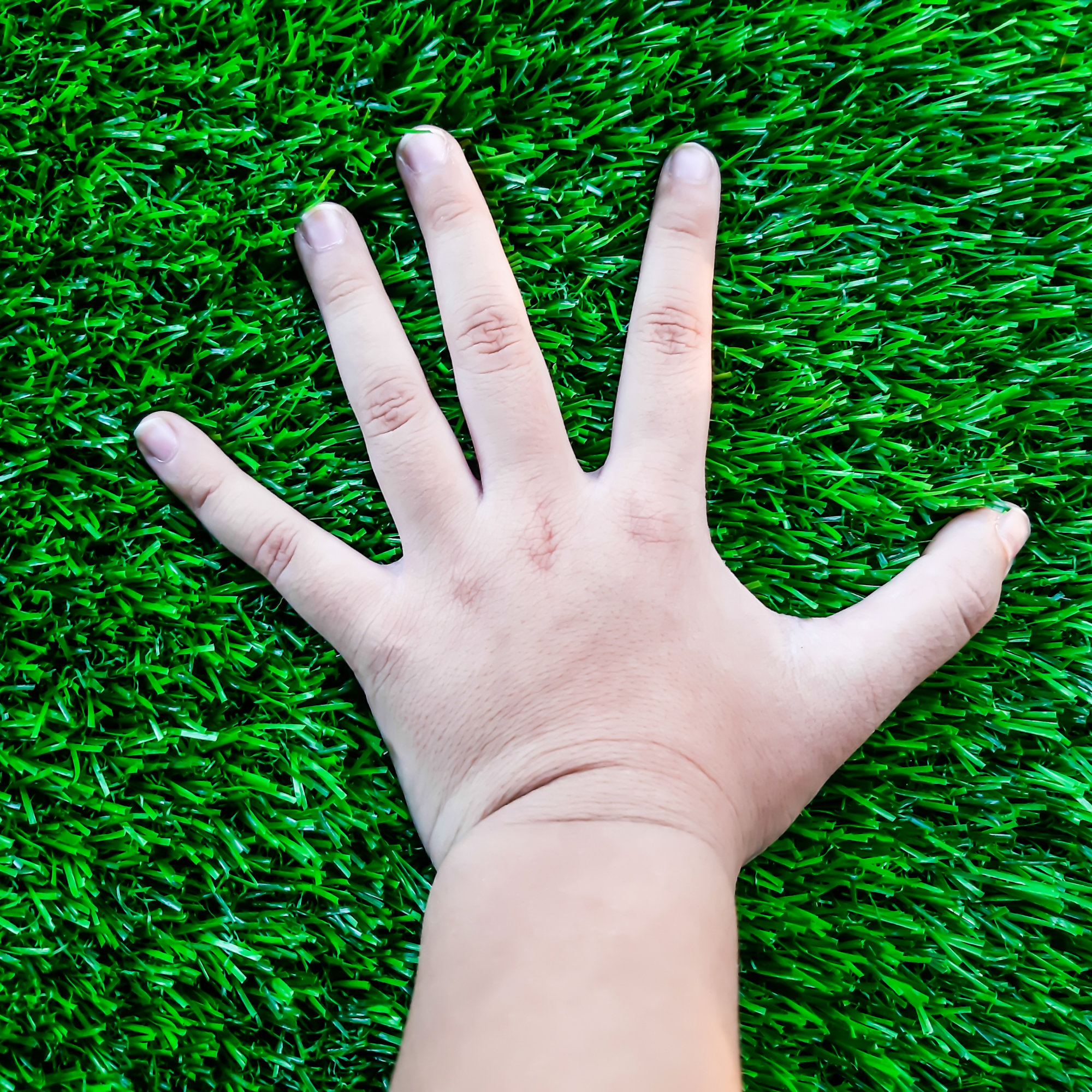Hand on artificial grass