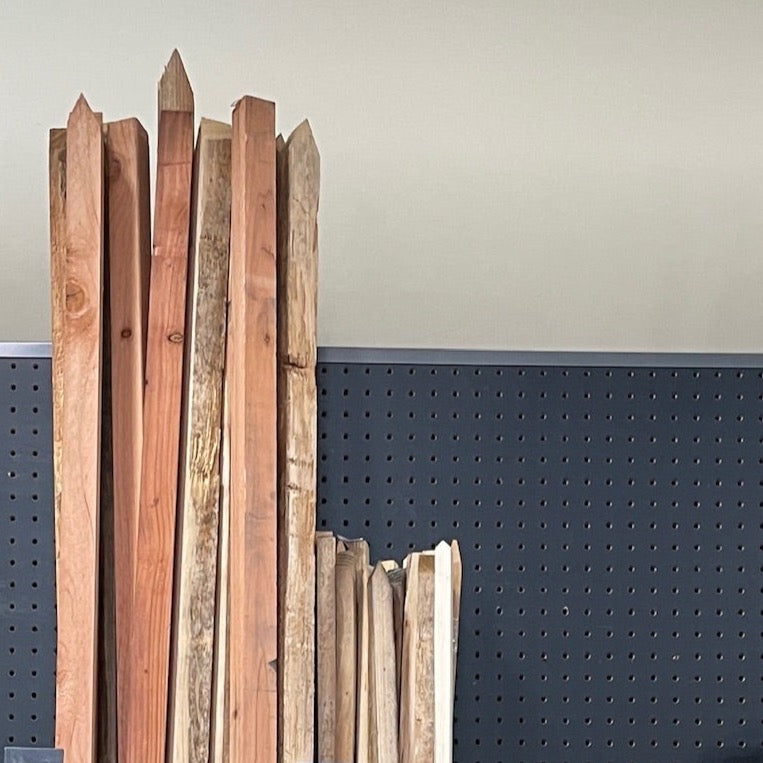 Stack of wooden planks against a gray wall