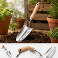 Gardening trowel on soil with potted plants in the background
