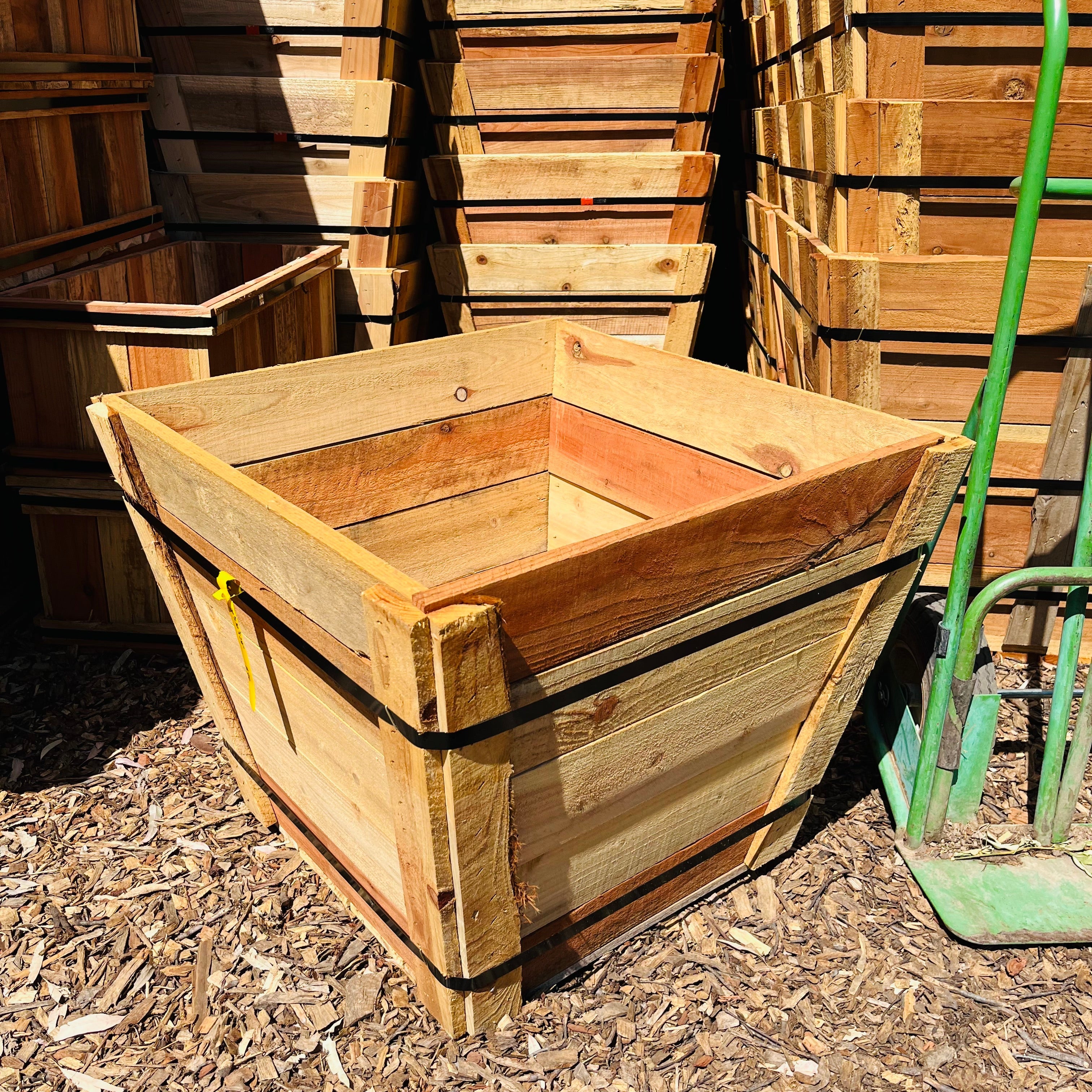 Wooden crate on a pile of wood chips with stacks of crates in the background.