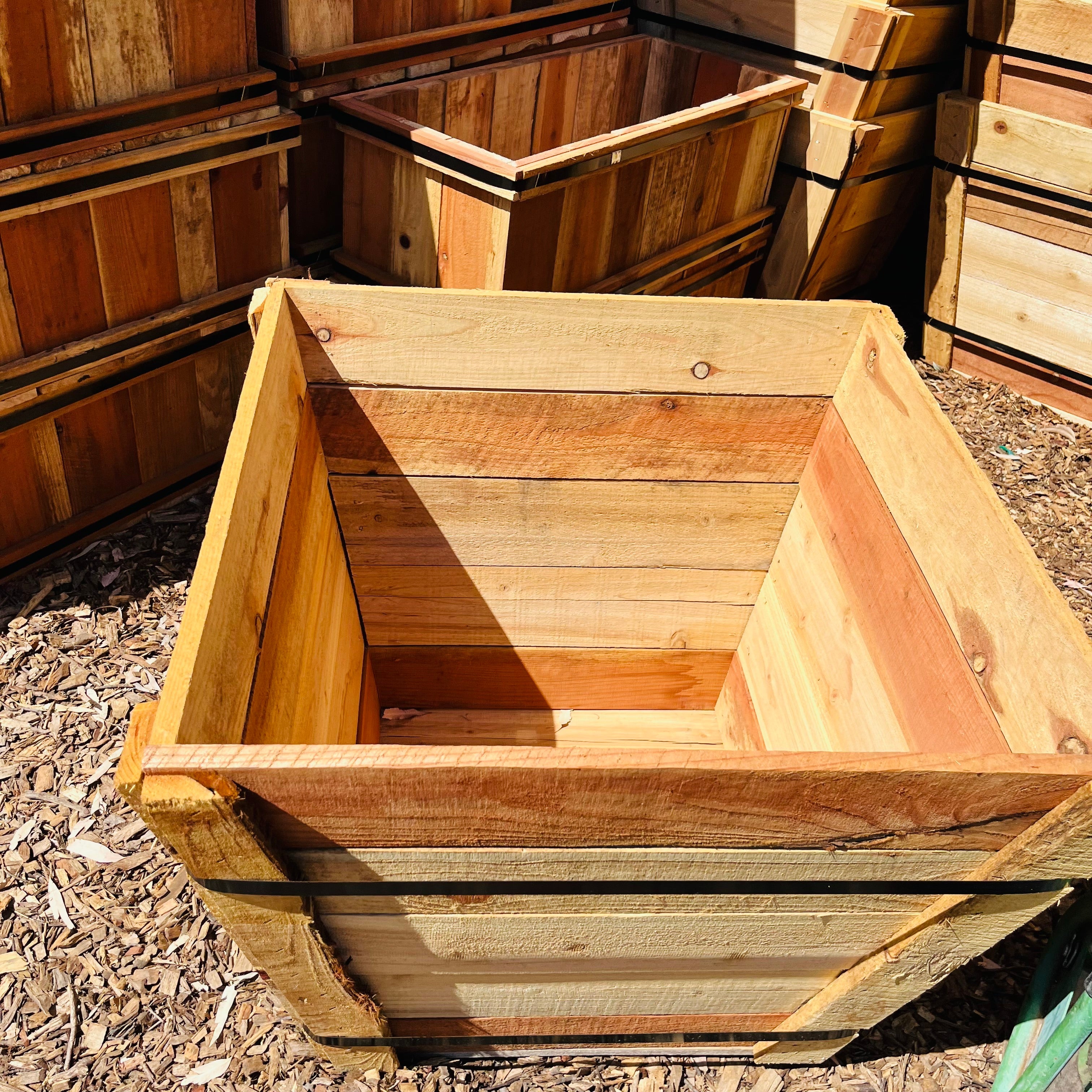 Wooden planter boxes stacked on a ground surface